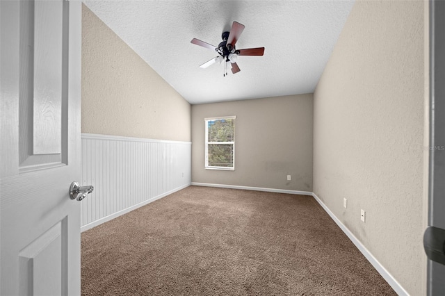 empty room with carpet, ceiling fan, lofted ceiling, and a textured ceiling