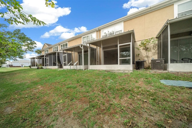 rear view of property featuring a yard and central AC