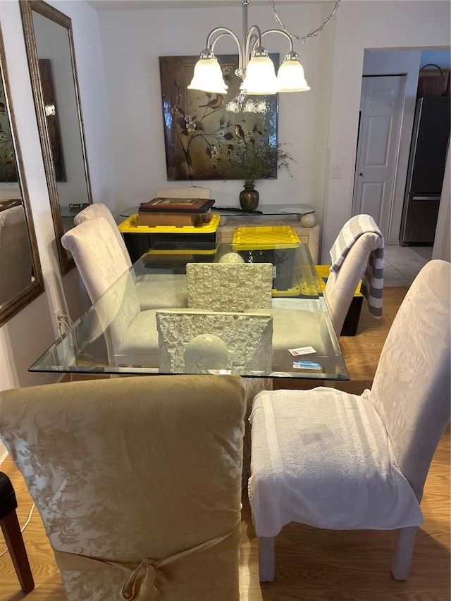 dining space with hardwood / wood-style floors and a chandelier