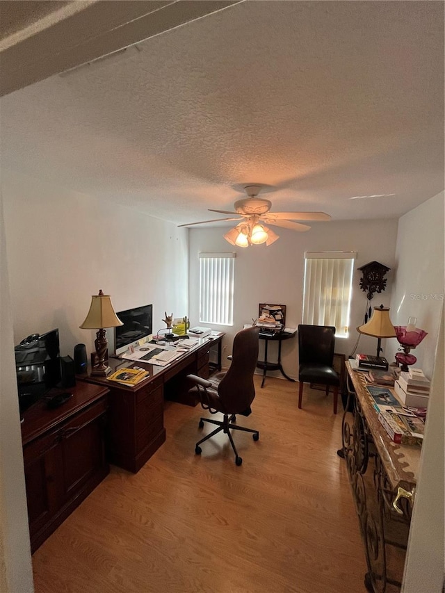 office with ceiling fan, light hardwood / wood-style flooring, and a textured ceiling