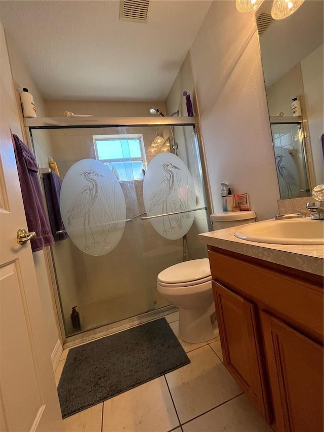 bathroom featuring tile patterned floors, an enclosed shower, a textured ceiling, vanity, and toilet