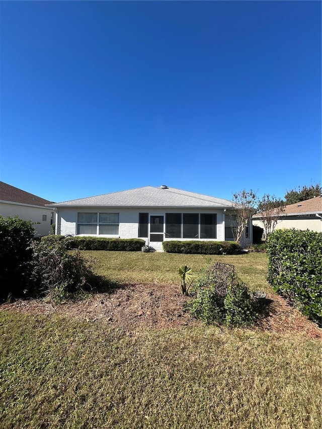 rear view of house featuring a lawn