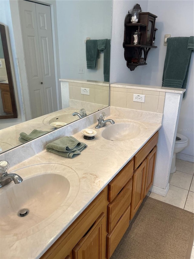 bathroom featuring toilet, vanity, and tile patterned floors