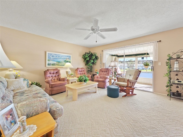 carpeted living room with ceiling fan and a textured ceiling