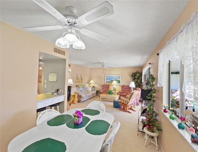 carpeted dining room featuring a textured ceiling and ceiling fan