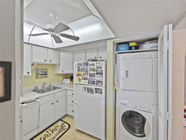 kitchen featuring stacked washer / dryer, sink, white cabinets, and white appliances