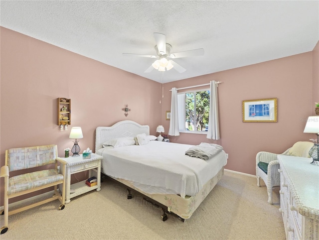 carpeted bedroom with ceiling fan and a textured ceiling