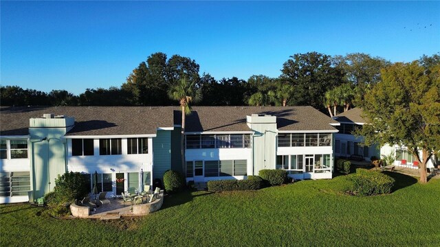 back of house featuring a lawn and a patio