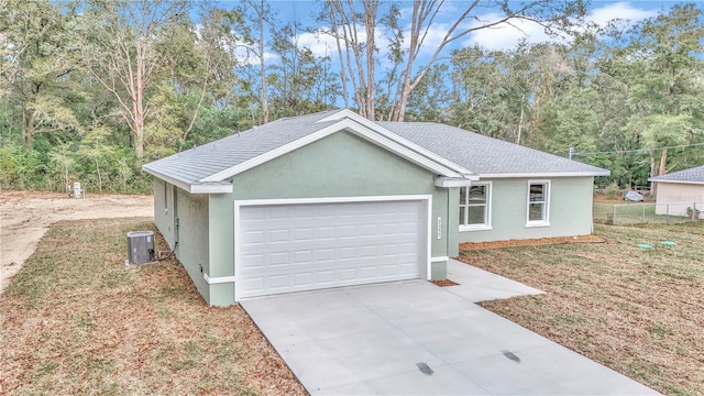 view of front of property featuring a front lawn, a garage, and cooling unit