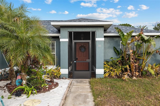 view of exterior entry featuring a yard