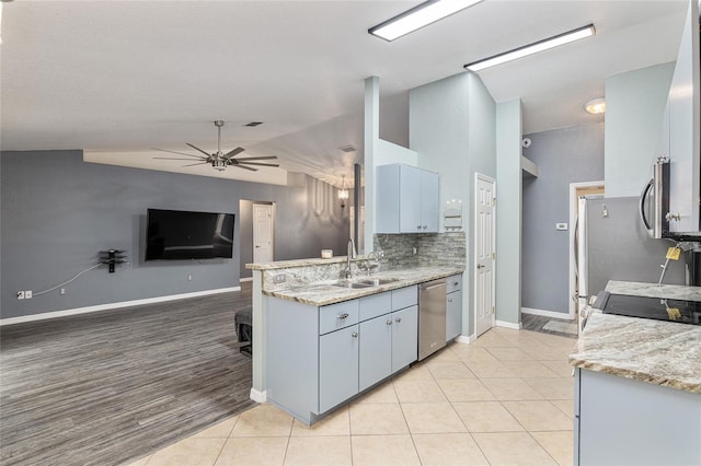 kitchen featuring stainless steel appliances, sink, lofted ceiling, ceiling fan, and backsplash