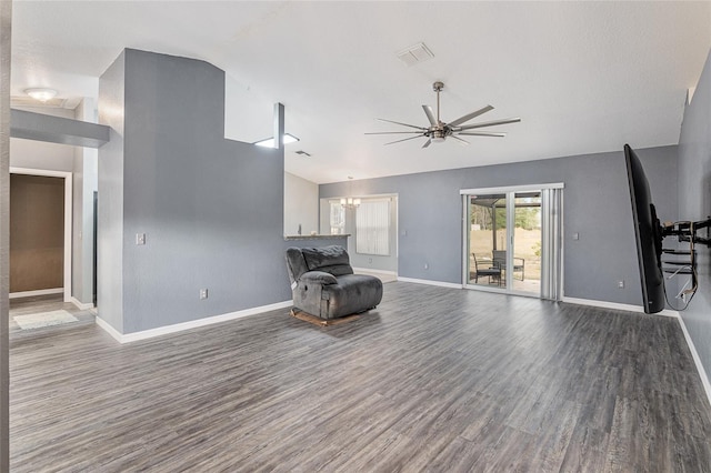 sitting room with lofted ceiling, wood-type flooring, and ceiling fan with notable chandelier