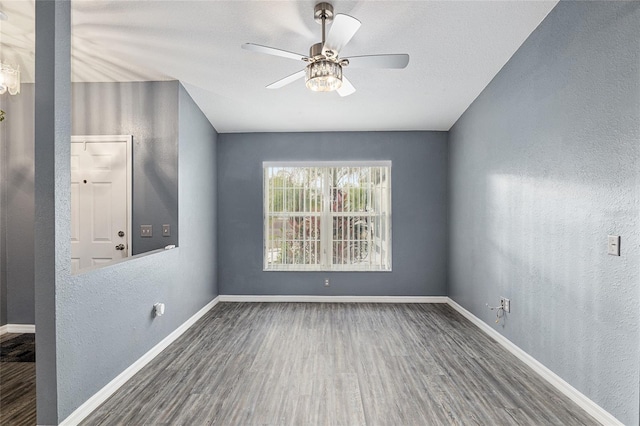 spare room featuring dark hardwood / wood-style flooring and ceiling fan