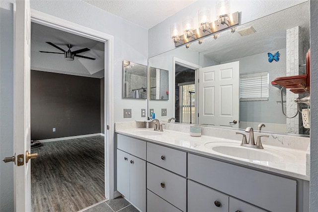 bathroom with ceiling fan, vanity, a textured ceiling, and hardwood / wood-style flooring