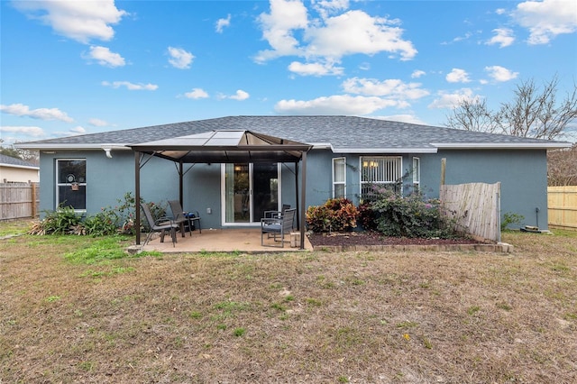 rear view of property with a lawn, a gazebo, and a patio area