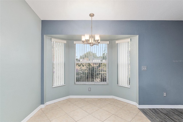 unfurnished room with an inviting chandelier