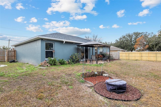 rear view of house with a gazebo and a yard