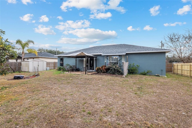 back of house with a gazebo, a patio, a yard, and a shed