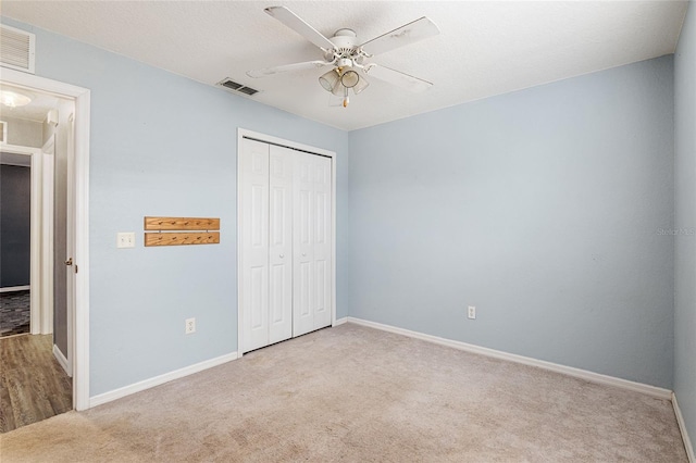 unfurnished bedroom with ceiling fan, a closet, and carpet