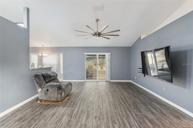 unfurnished room featuring ceiling fan with notable chandelier, vaulted ceiling, and dark hardwood / wood-style floors