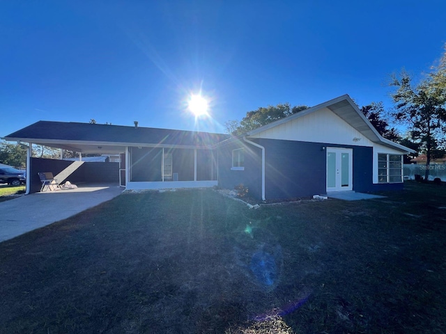 ranch-style home with a carport, a front lawn, and french doors