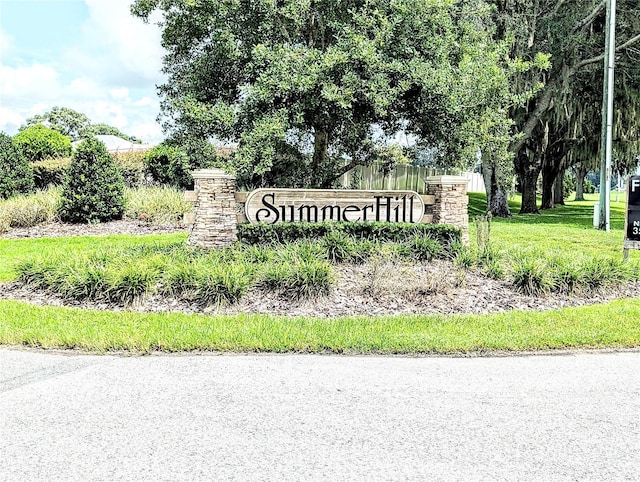 community / neighborhood sign featuring a lawn