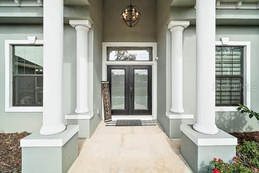 property entrance featuring french doors and a porch