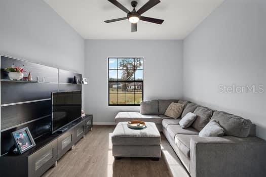 living room featuring ceiling fan and light wood-type flooring