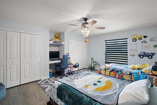 bedroom featuring ceiling fan, a closet, and hardwood / wood-style flooring