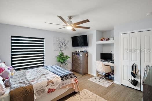 bedroom featuring a closet, light hardwood / wood-style flooring, and ceiling fan