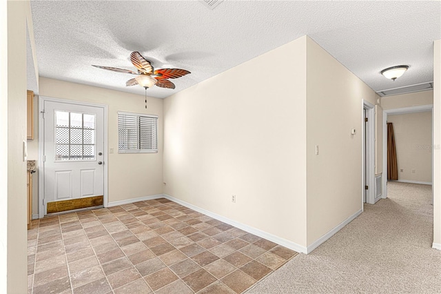 interior space with ceiling fan and a textured ceiling