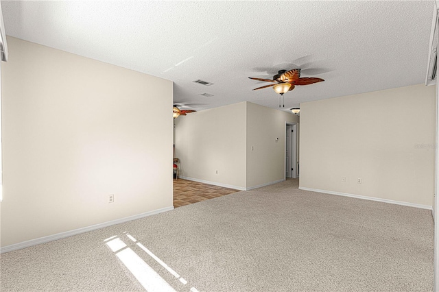 empty room featuring light carpet, ceiling fan, and a textured ceiling