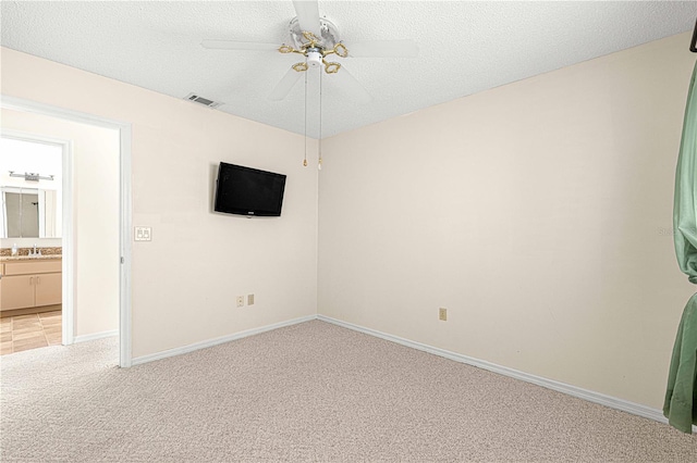 carpeted empty room with ceiling fan, sink, and a textured ceiling