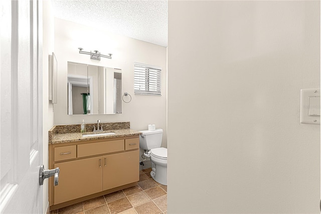 bathroom featuring vanity, toilet, and a textured ceiling