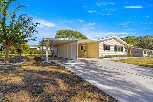 view of front of property with a front yard and a carport