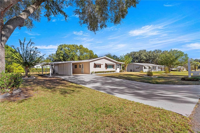 ranch-style home featuring a front lawn and a carport