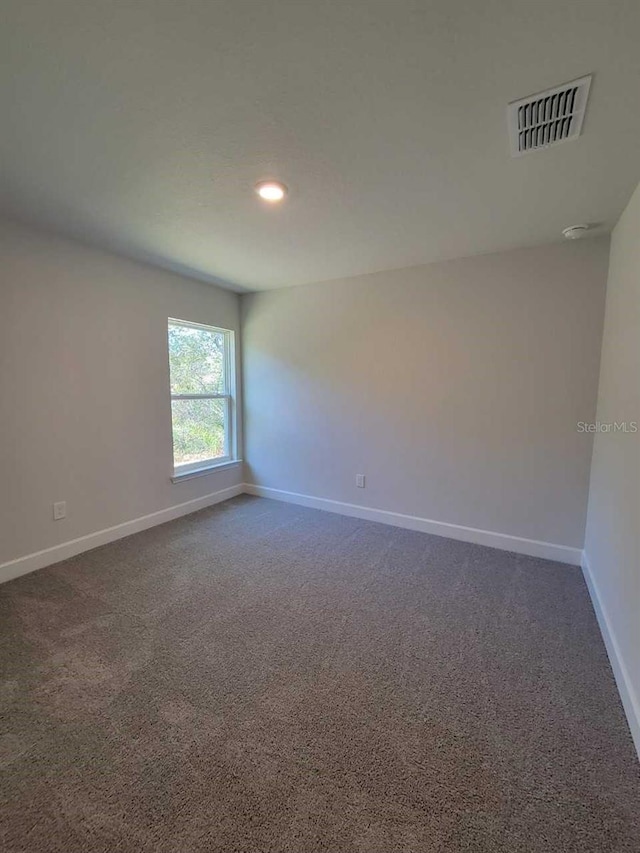 unfurnished room with recessed lighting, baseboards, visible vents, and dark colored carpet