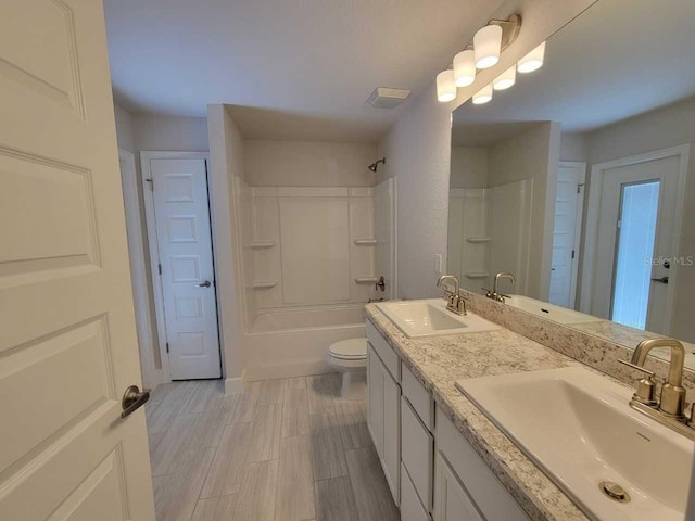 bathroom featuring double vanity, toilet, and a sink