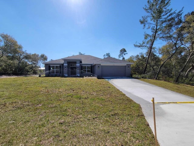 view of front of property featuring a front lawn, a garage, driveway, and stucco siding