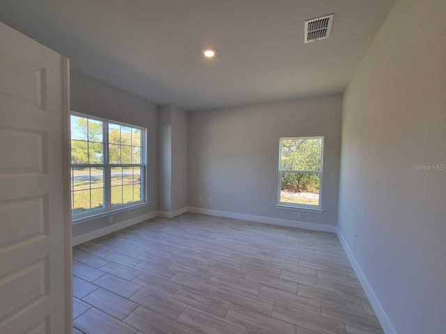 spare room featuring recessed lighting, visible vents, baseboards, and wood tiled floor