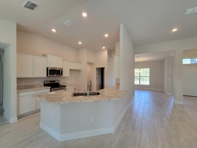 kitchen featuring visible vents, appliances with stainless steel finishes, white cabinetry, and a sink