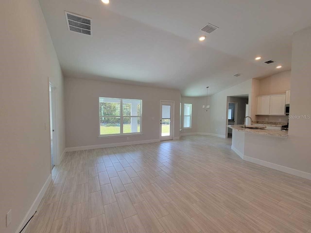 unfurnished living room with visible vents, recessed lighting, light wood-style floors, and vaulted ceiling