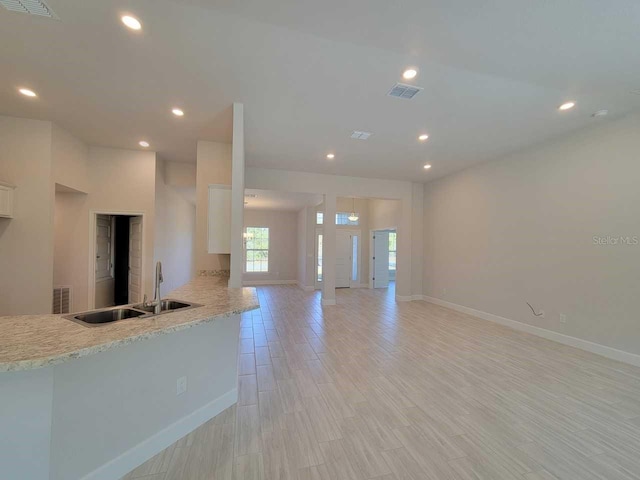 kitchen with a sink, visible vents, light wood-style floors, and recessed lighting