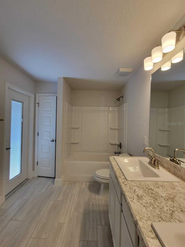 full bath featuring wood finish floors, shower / bathtub combination, toilet, and vanity