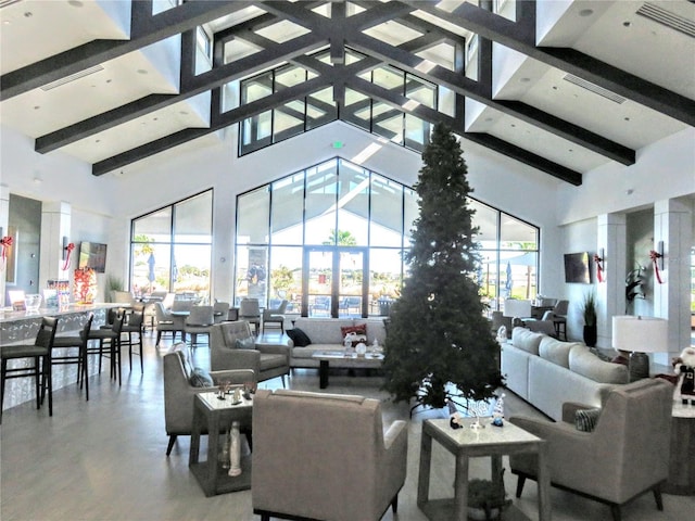 living room with beam ceiling and a high ceiling