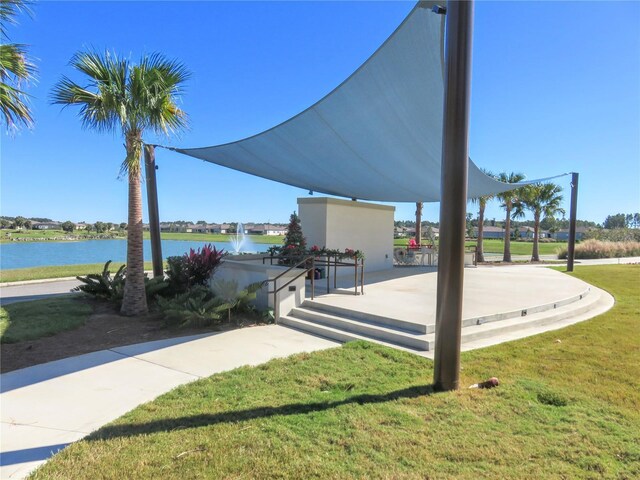 view of property's community featuring a yard and a water view