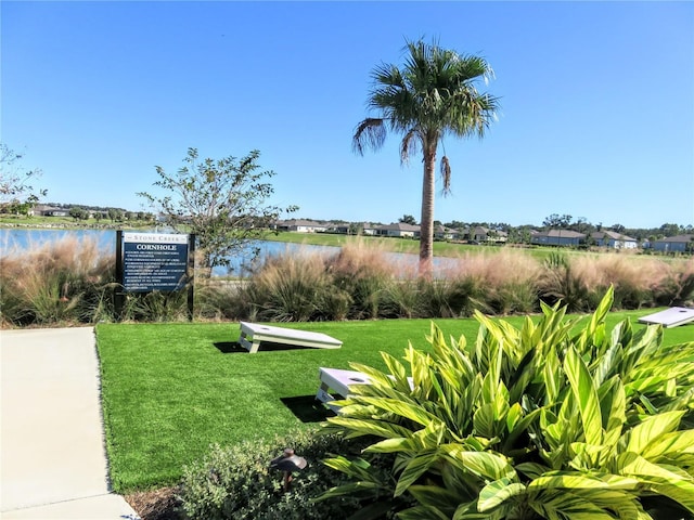 view of community featuring a water view and a yard