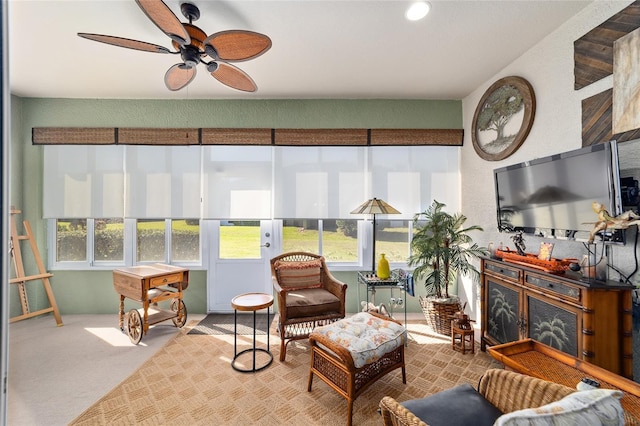 sunroom featuring ceiling fan and a glass covered fireplace