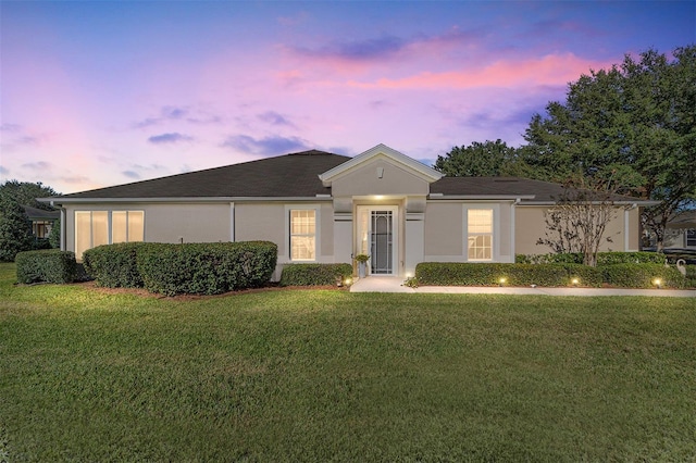 single story home featuring a yard and stucco siding