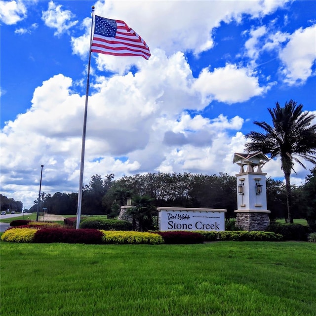 community / neighborhood sign featuring a yard